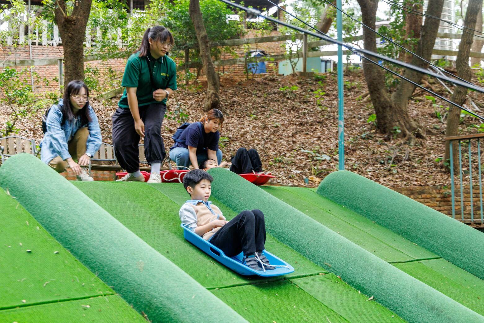 園區人員會教導正確的滑草方式，確保遊客安全。