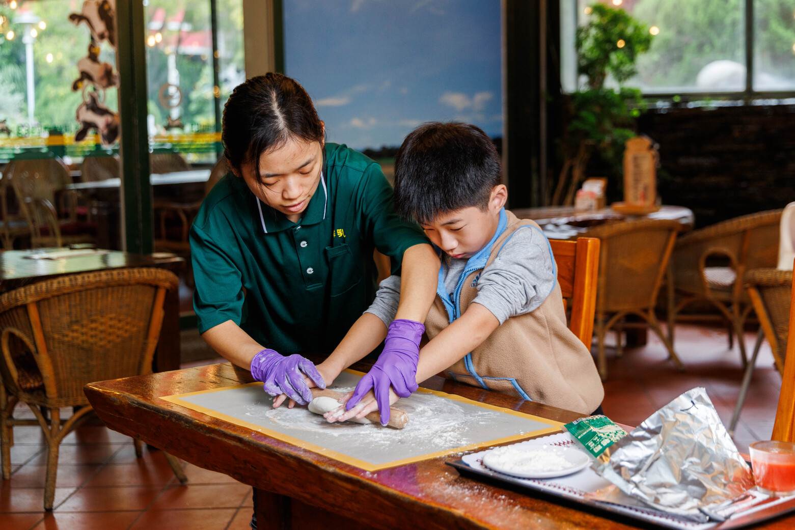 老師手把手教小朋友如何擀麵皮，製作pizza。